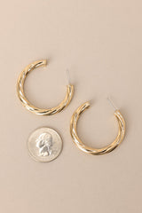 Size comparison of These earrings feature gold hardware, a twist like design, and a secure post backing.