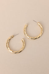 Side view of these earrings feature gold hardware, a twist like design, and a secure post backing.