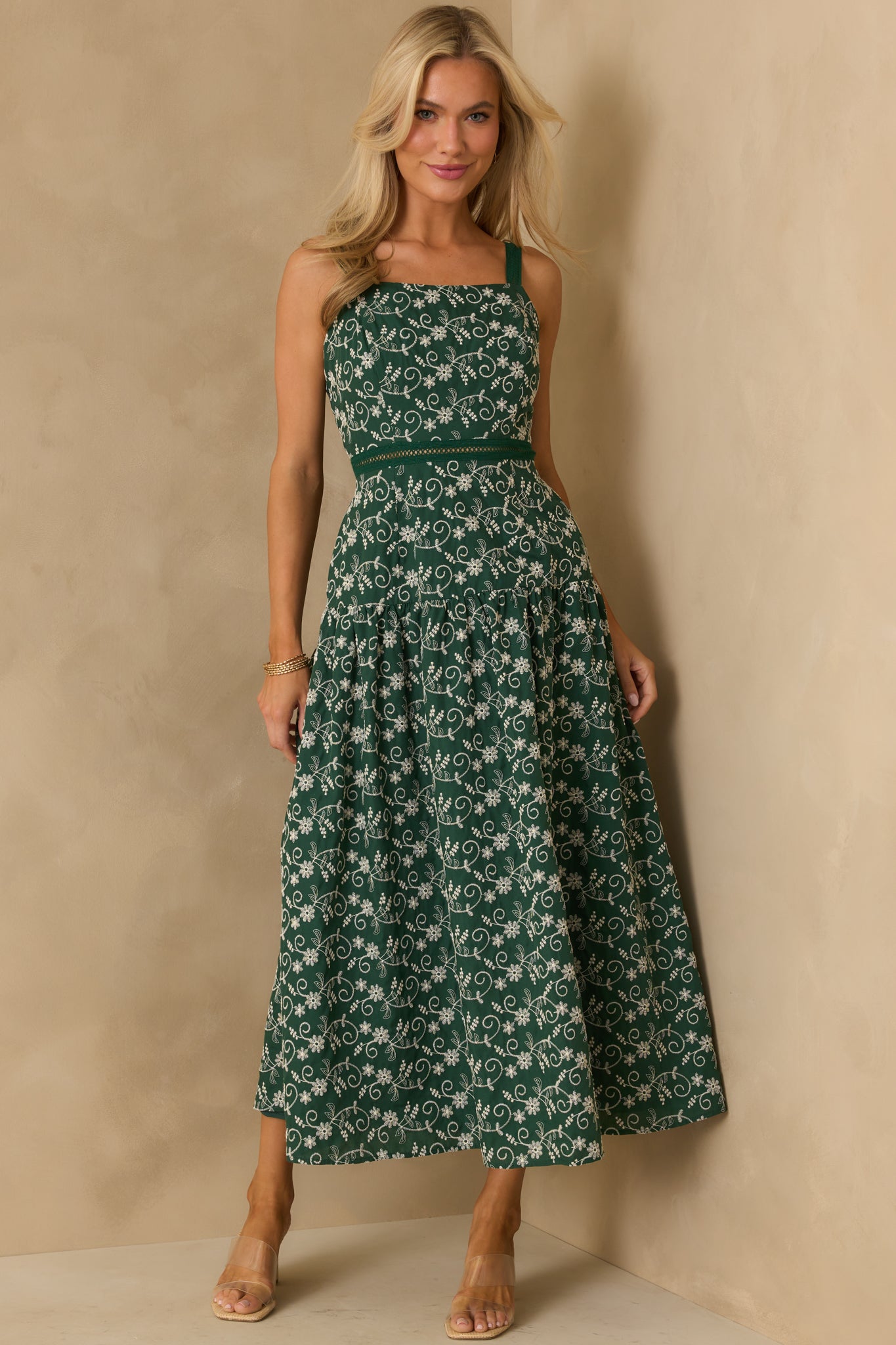 Full view of the hunter green dress highlighting the drop waist silhouette and open ladder-lace detail at the waist.