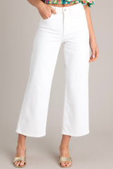 Front view of these white jeans that feature a high waisted design, classic button & zipper closure, belt loops, functional front & back pockets, and a cropped length.