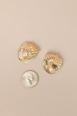 Size comparison of these gold earrings with intertwined design and small faux pearl detailing, secure post backings.