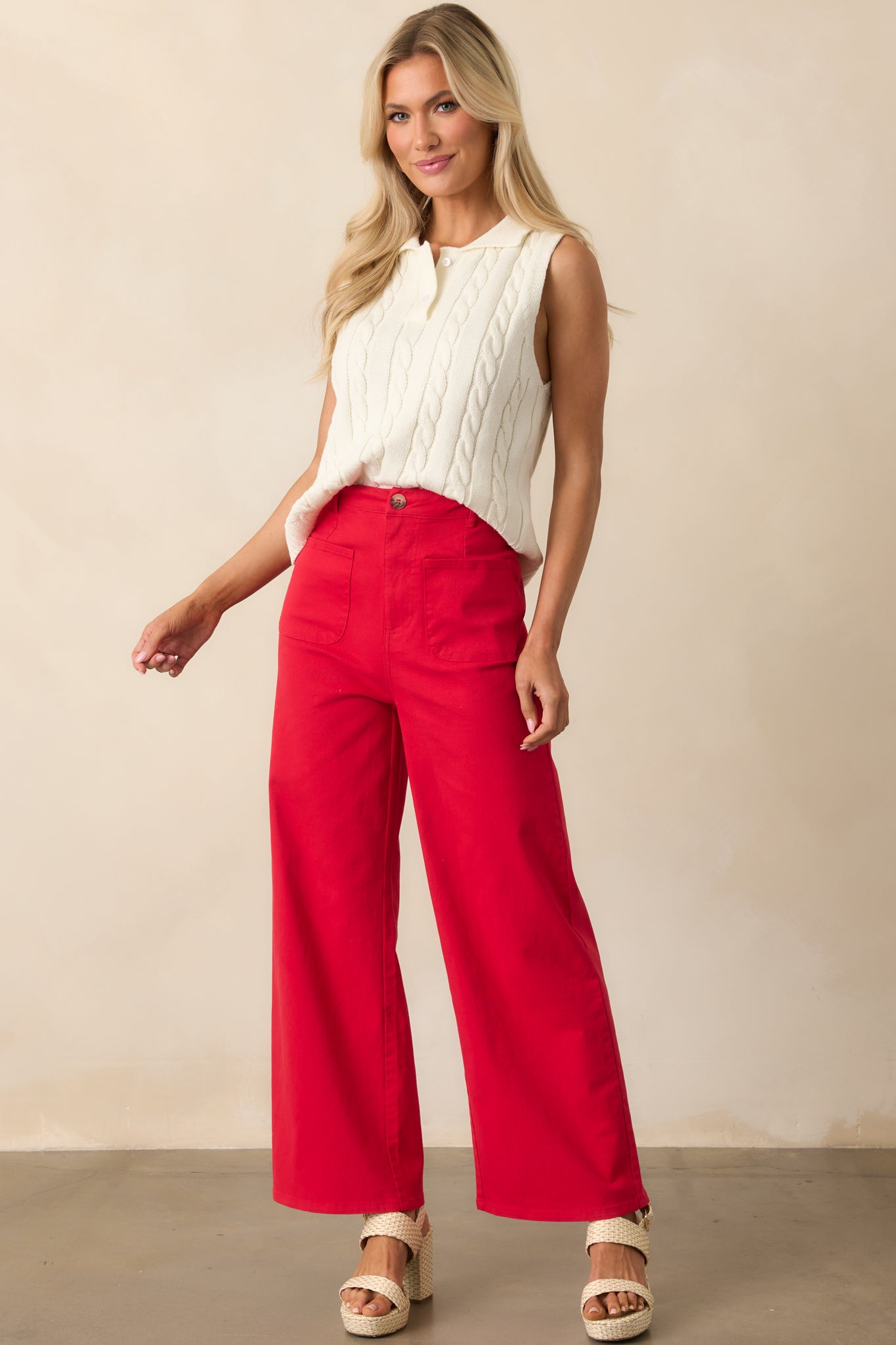 A full-length view of the ivory sweater vest with a cable knit texture and collared polo neckline, styled in a relaxed silhouette.