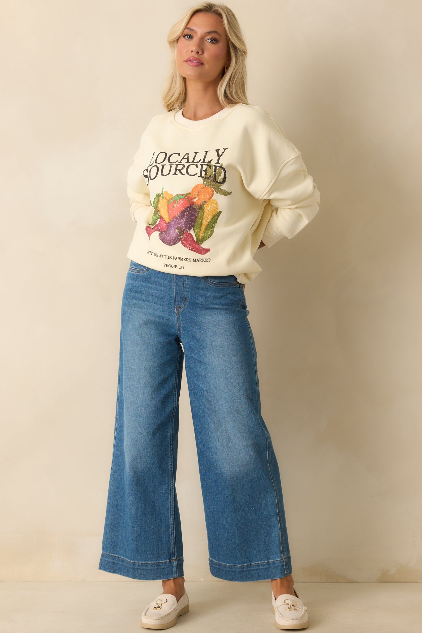 Ivory cotton sweatshirt with colorful 'Locally Sourced' vegetable graphic shown in full front view.