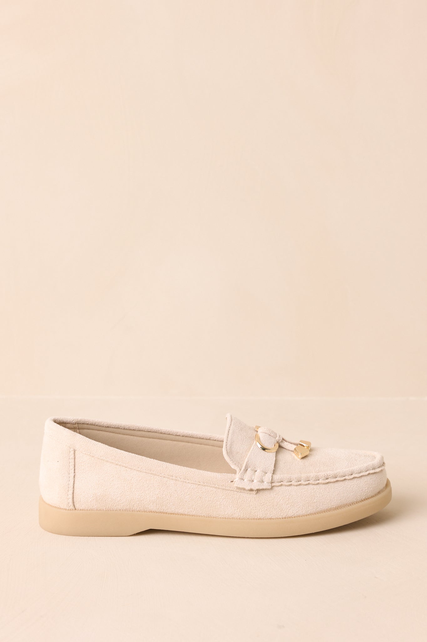 Side profile of ivory faux suede loafers with saddle strap and platform sole.