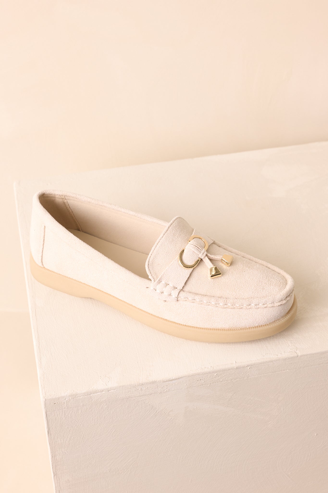 An angled overhead view of the loafers showing their beige platform sole and stitched detailing.