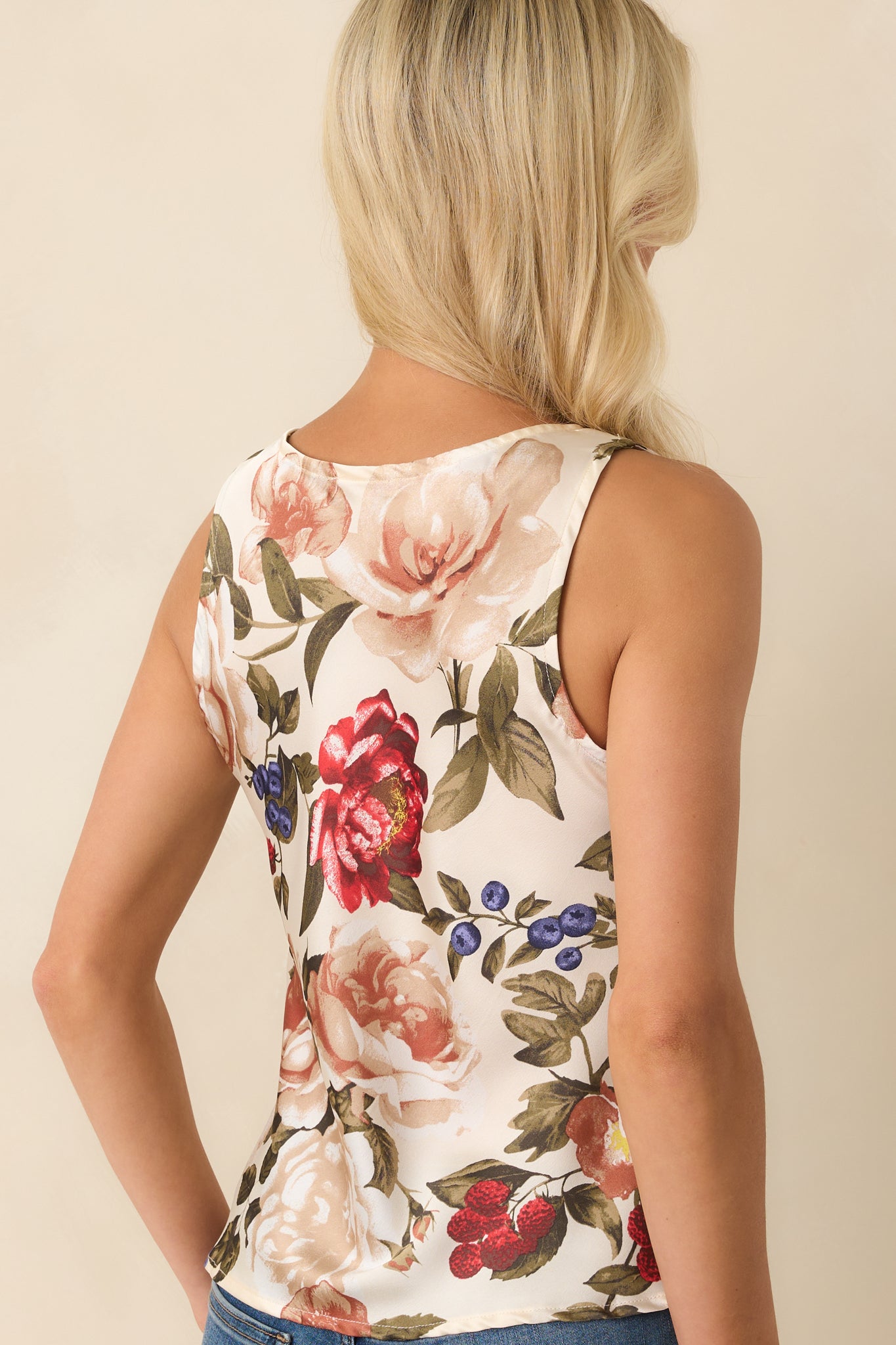 A back view of the ivory top showing the sleeveless cut and continuation of the multicolor floral print.