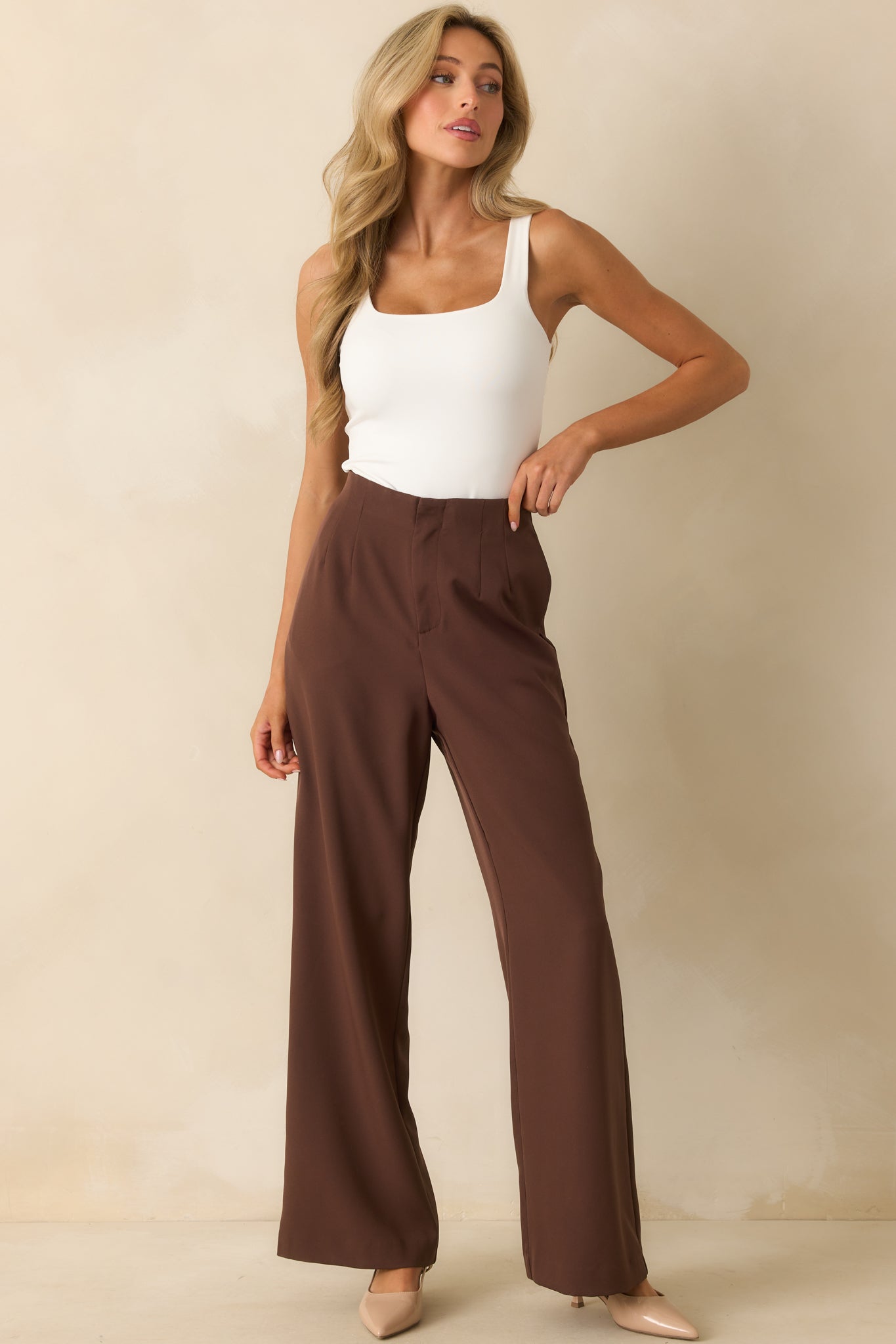 Ivory sleeveless bodysuit with square neckline and fitted stretchy fabric.