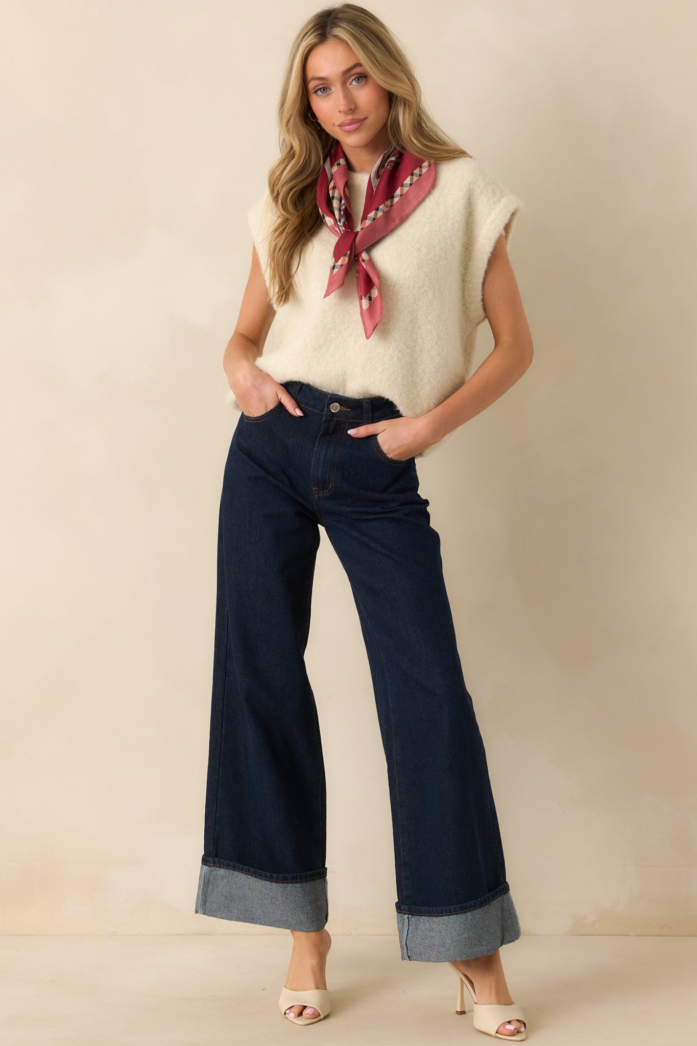 Ivory-colored sweater vest with a crew neckline and oversized, sleeveless design.