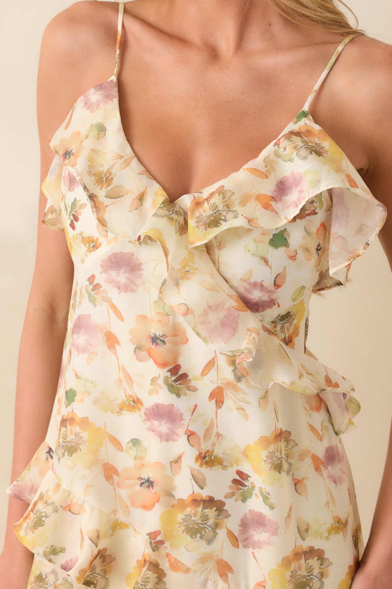 A close-up of the neckline area showing the floral chiffon overlay, delicate straps, and ruffle accents.