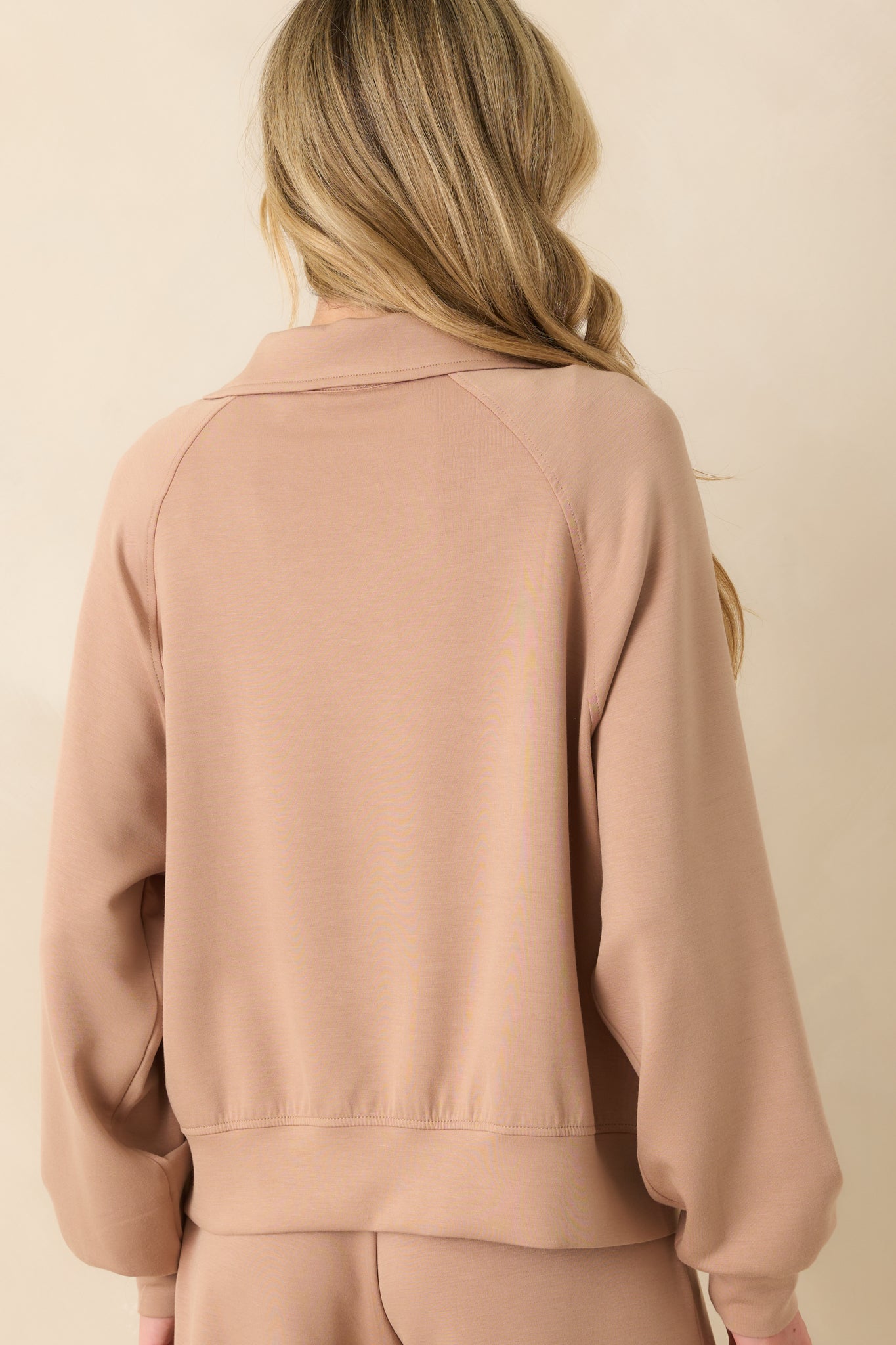 The back view of the jacket displaying the smooth back panel, relaxed fit, and thick hemline.