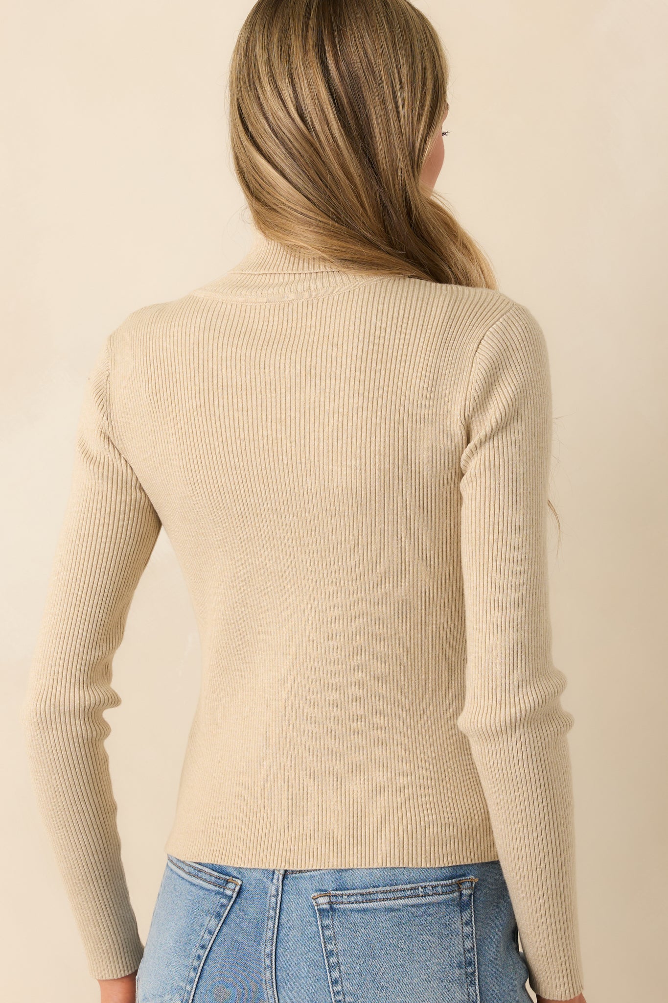 Back view of the sweater displaying the consistent ribbed pattern and the smooth, seamless turtleneck from behind.