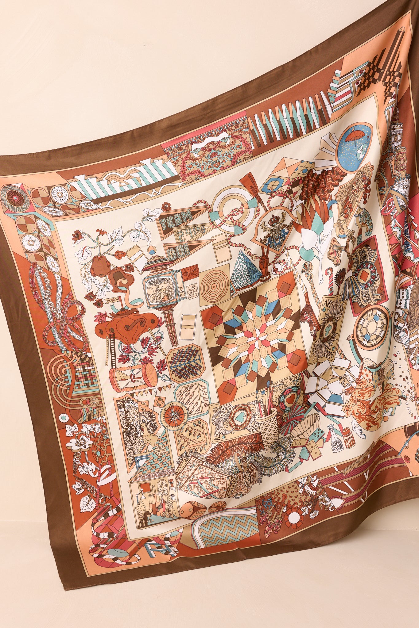 Full view of the large square scarf laid flat, featuring a satin finish and a mix of brown multicolor prints with various motifs throughout.