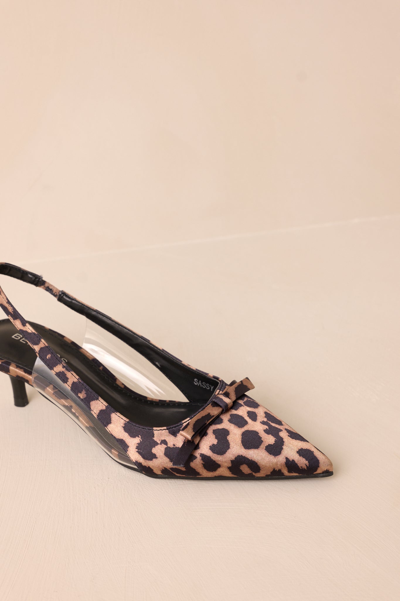 Close-up of the leopard kitten heels showing the pointed closed toe, delicate bow detailing, and clear siding for extra support.