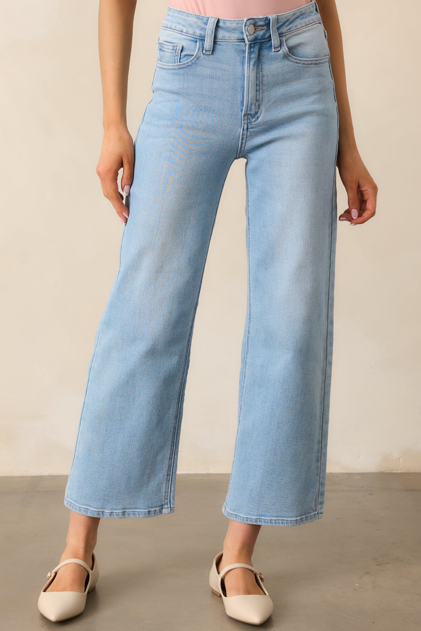 A closer view of these light wash jeans, highlighting the belt loops and front pocket details.