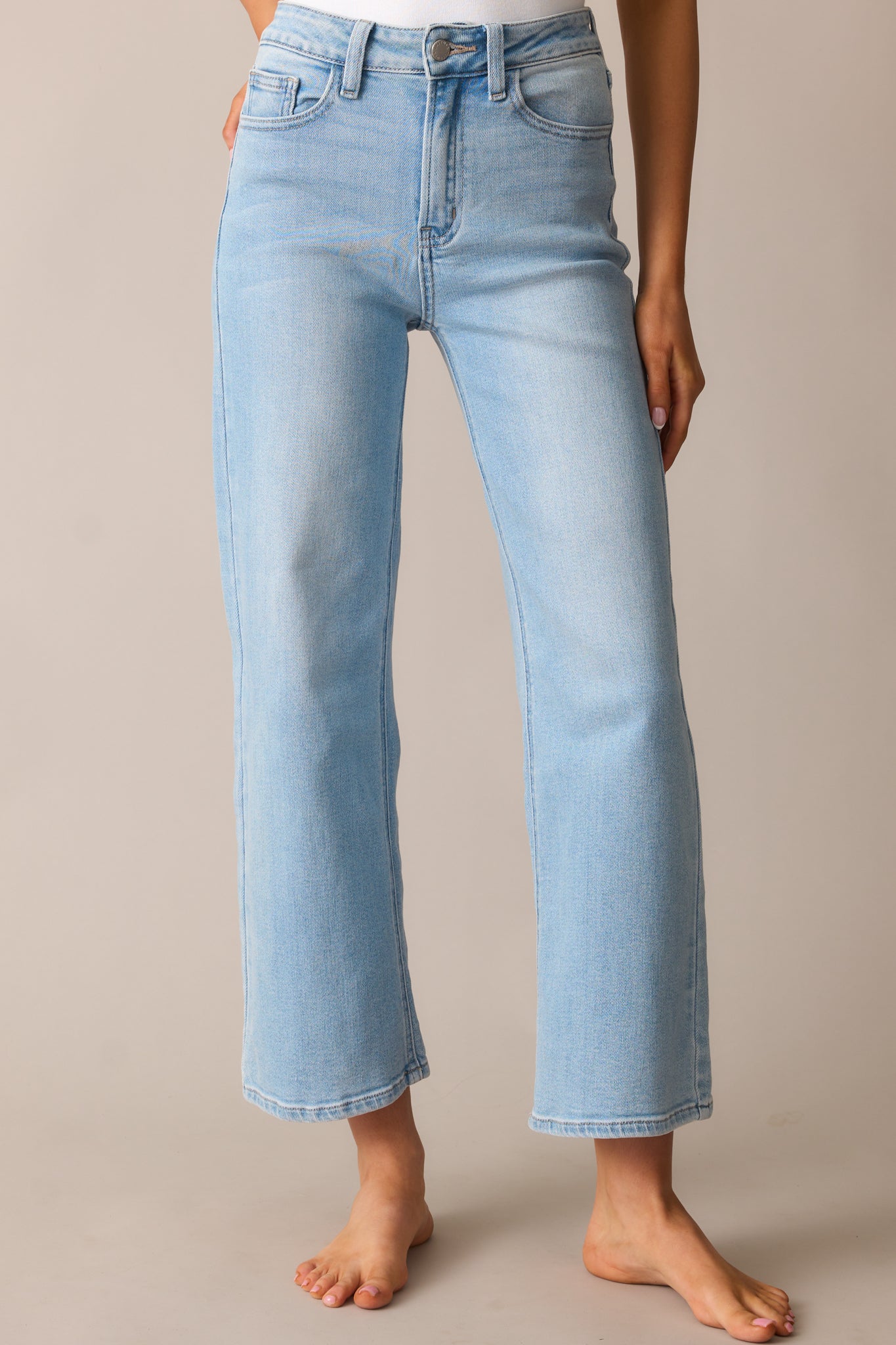 A detailed view of the jeans’ cropped length, highlighting the clean hemline, light wash denim, and straight-leg fit.
