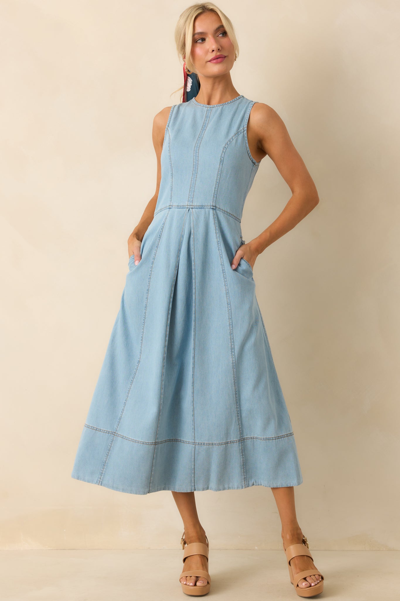 Lightweight chambray midi dress featuring round neckline, pleated front, and relaxed fit.