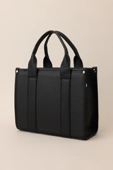 Back view of this black faux leather bag that features silver hardware, top handles, a functional zipper closure, an additional pocket on the inside, and a removable strap