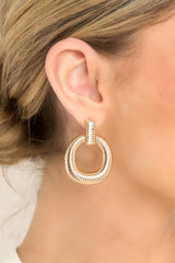 These gold earrings showcase a rectangular ribbed stud connected to a ribbed hoop, offering a stylish and coordinated look.