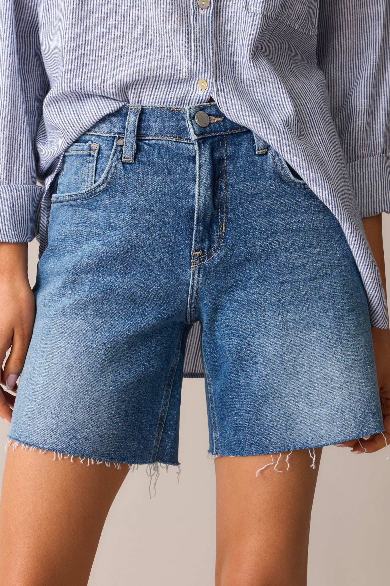 Detailed close-up of the front closure, including the metal button, zipper, and topstitching around the waistband.