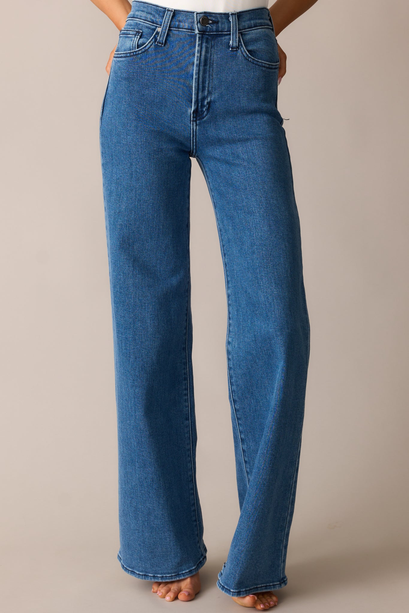 A closer look at the jeans’ high-waisted design, functional front pockets, and classic button-zipper closure.