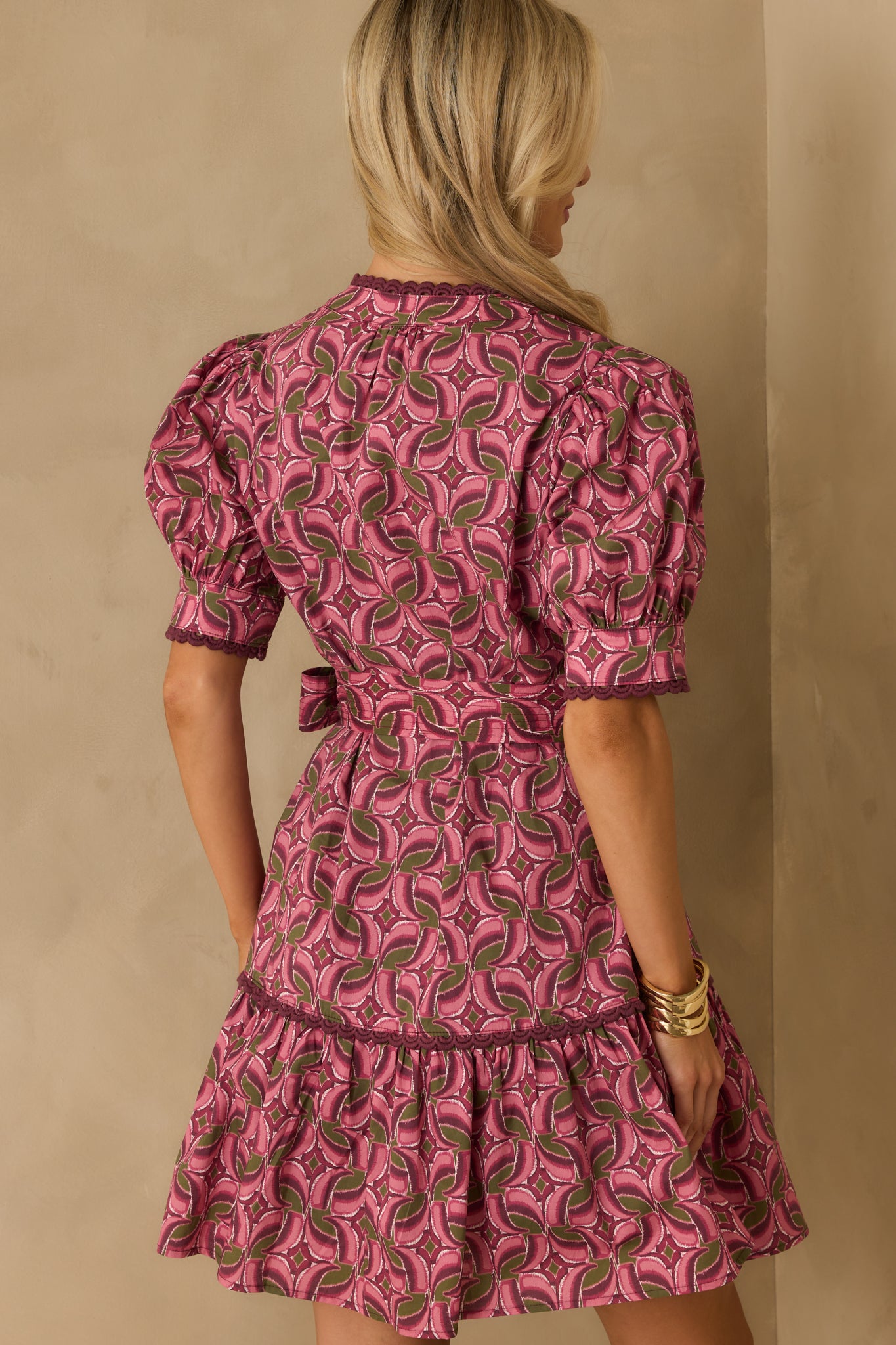 Rear view of the mini dress showing the tiered skirt, short sleeves, and allover geometric print.