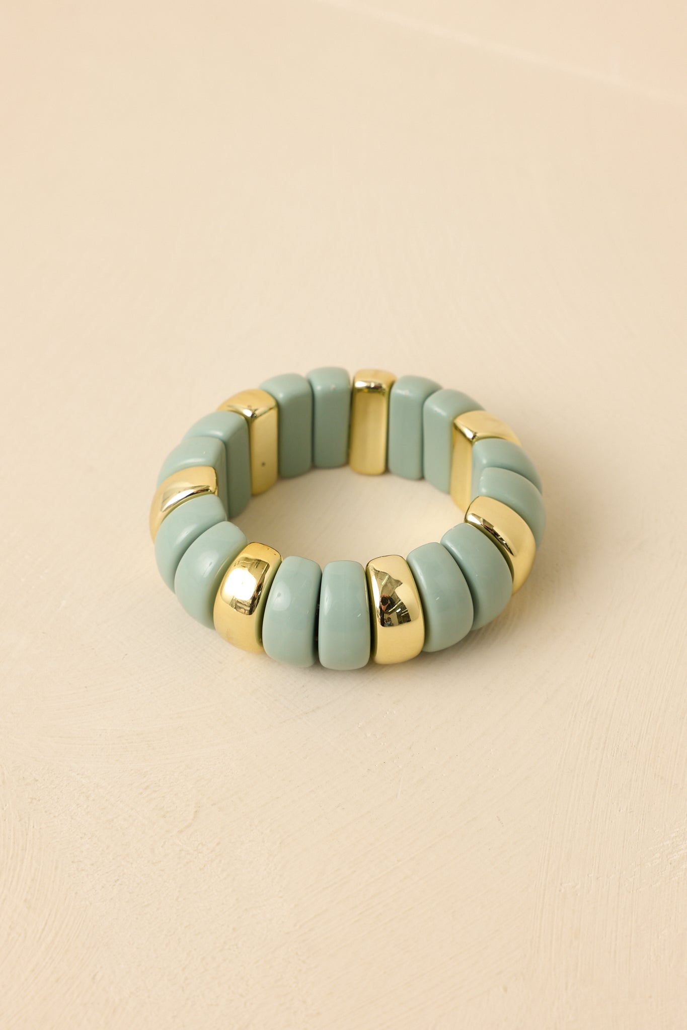 Mint green and gold stretch beaded bracelet featuring smooth enamel disc beads with polished gold accents for a modern, colorful statement.