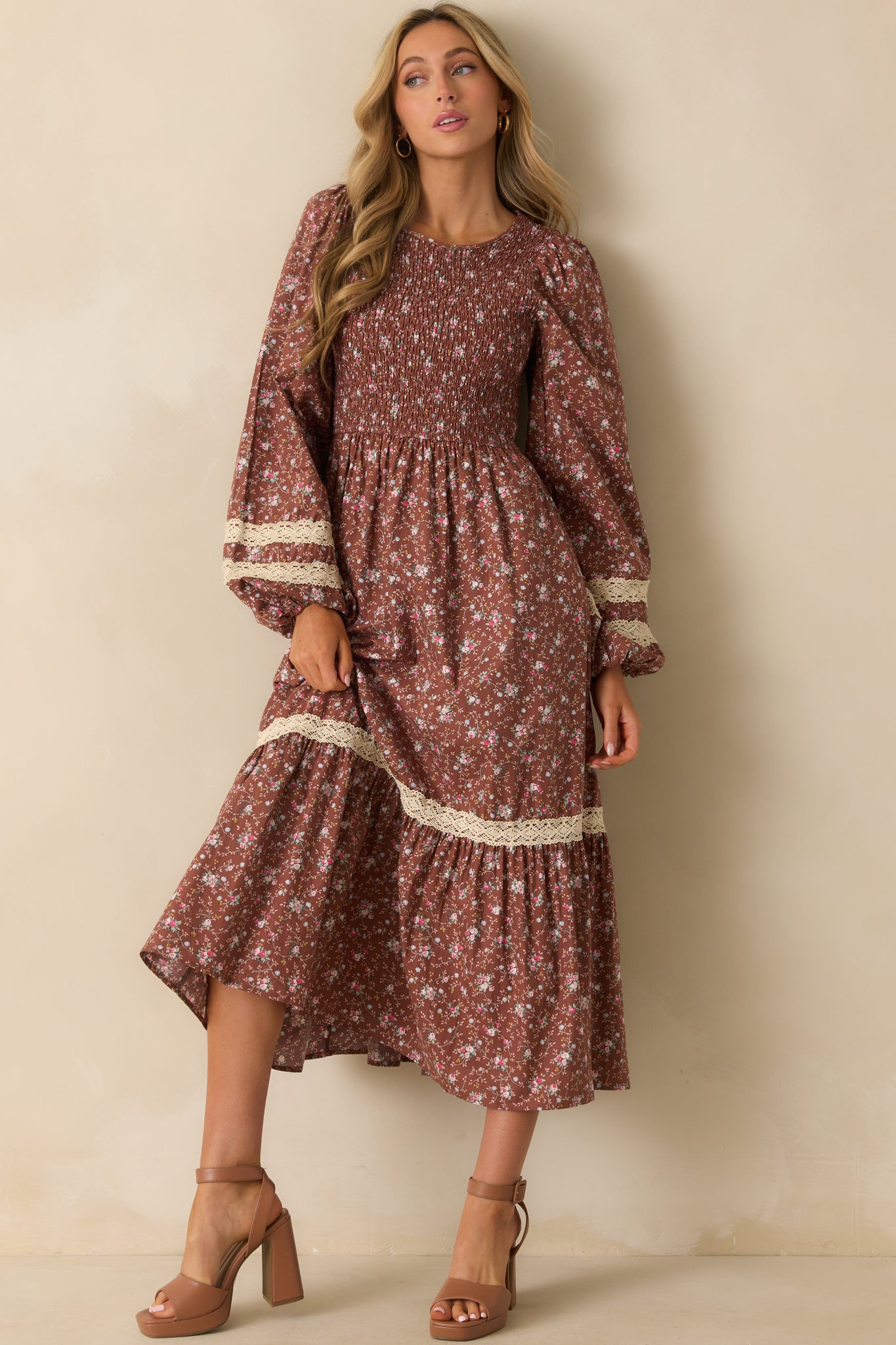 Mocha brown midi dress with a colorful floral print and a fully smocked bodice paired with a round neckline.
