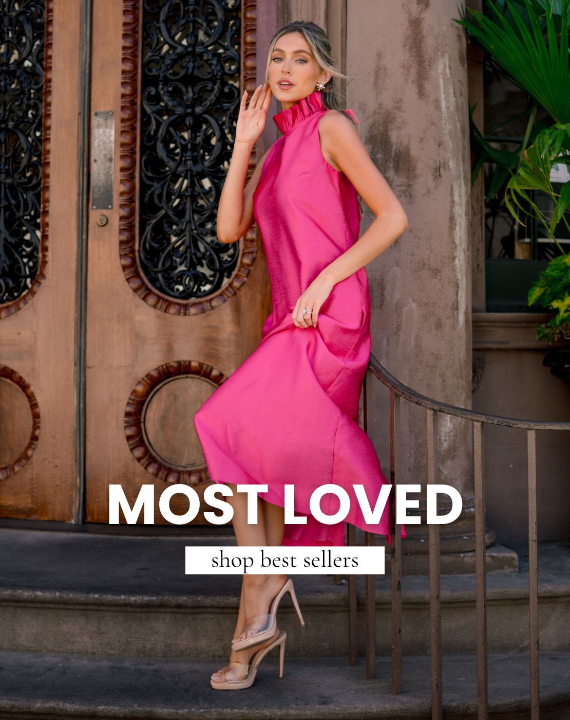 Woman wearing a sleeveless hot pink dress and nude heels, posing on steps in front of a brown door. Elegant summer dress that is featured in the Best Sellers collection. 