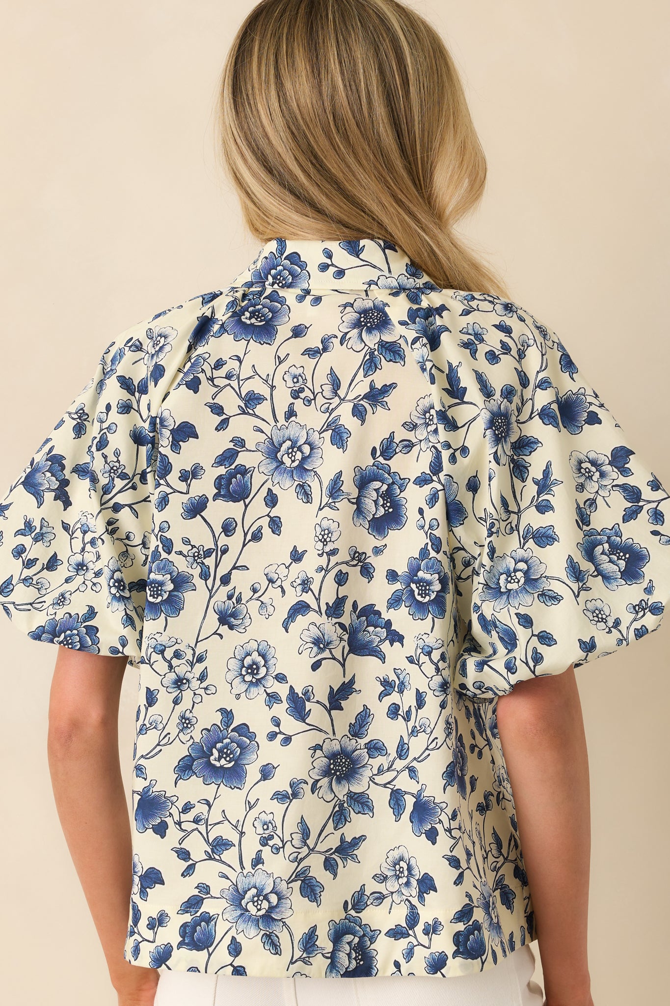 A back view of the top showing the relaxed fit, short sleeves, and full floral pattern continuing throughout.