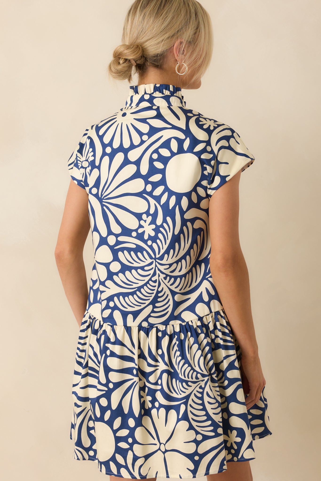 A back view of the mini dress showing the smooth finish with full white lining beneath.