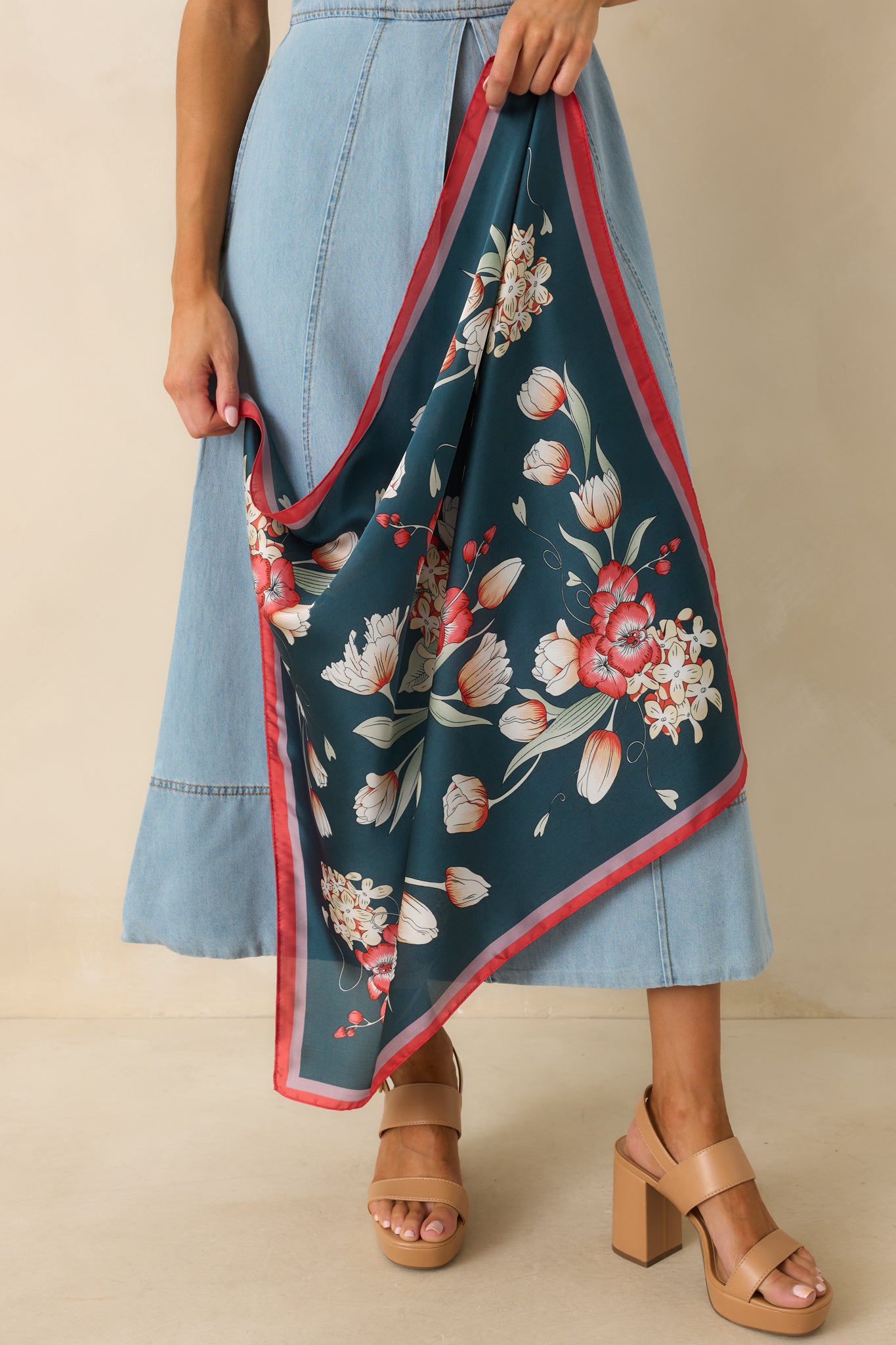 Full view of navy satin scarf showing vibrant floral pattern and contrasting red and pink border edges.