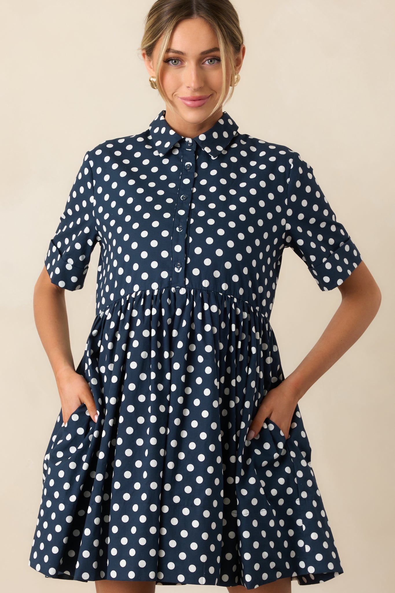 Close crop of short sleeve and polka dot fabric on navy mini dress.