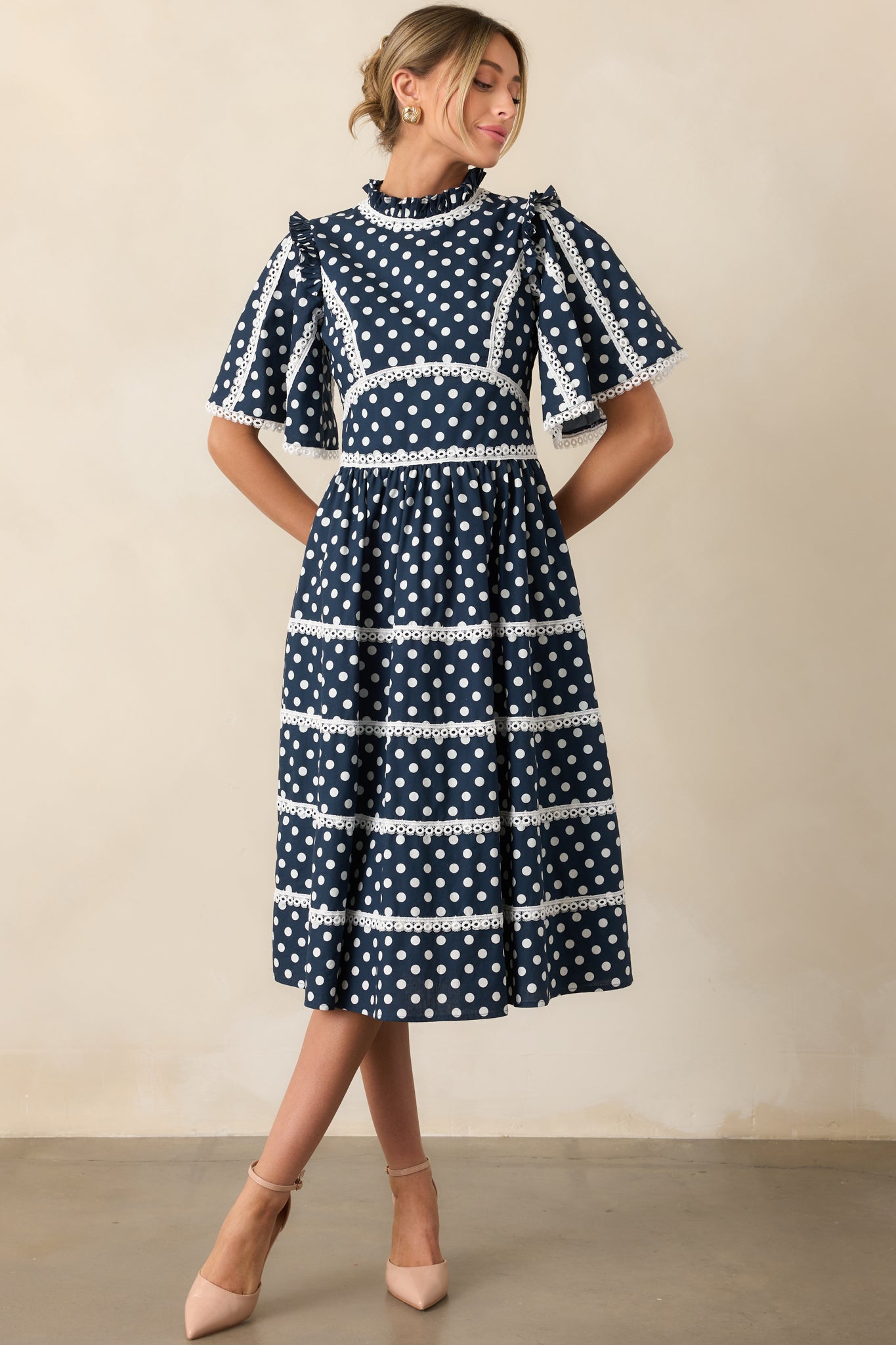 Navy midi dress with ruffle neckline, eyelet accents, and tiered design displayed from the front.