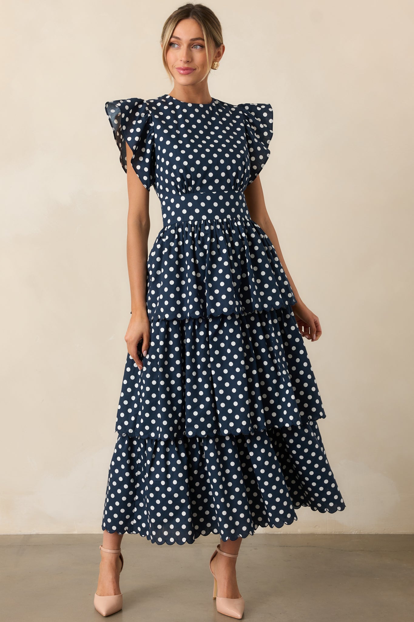 Front view of tiered maxi dress with scalloped hem and polka dot print.