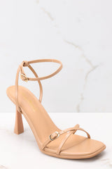 These light tan heels feature a thin adjustable ankle strap, straps over the toes, and this heel.