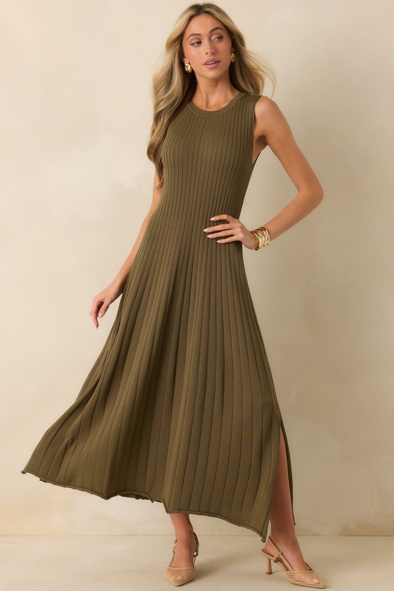 Sleeveless olive green midi dress with ribbed top, flowy skirt, and side slit detail.