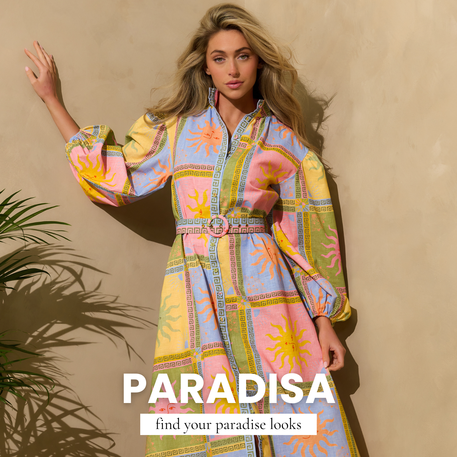 Blonde woman wearing a colorful patterned long-sleeve dress with sun motifs, posing against a neutral wall with “Paradisa” spring fashion text overlay.