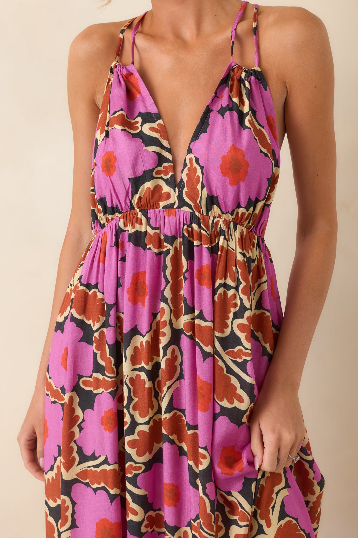Close-up of the pink floral maxi dress showcasing the deep V-neckline, empire waist, adjustable straps, and floral print.