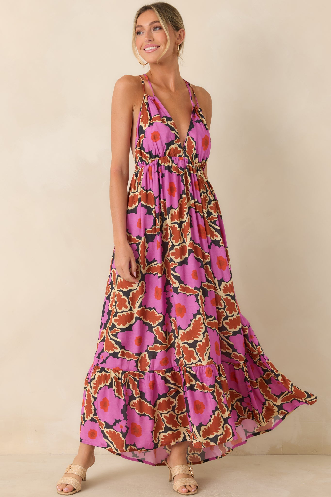 Front view of a pink and brown floral maxi dress featuring a plunging neckline, empire waist, and tiered ruffle hem.
