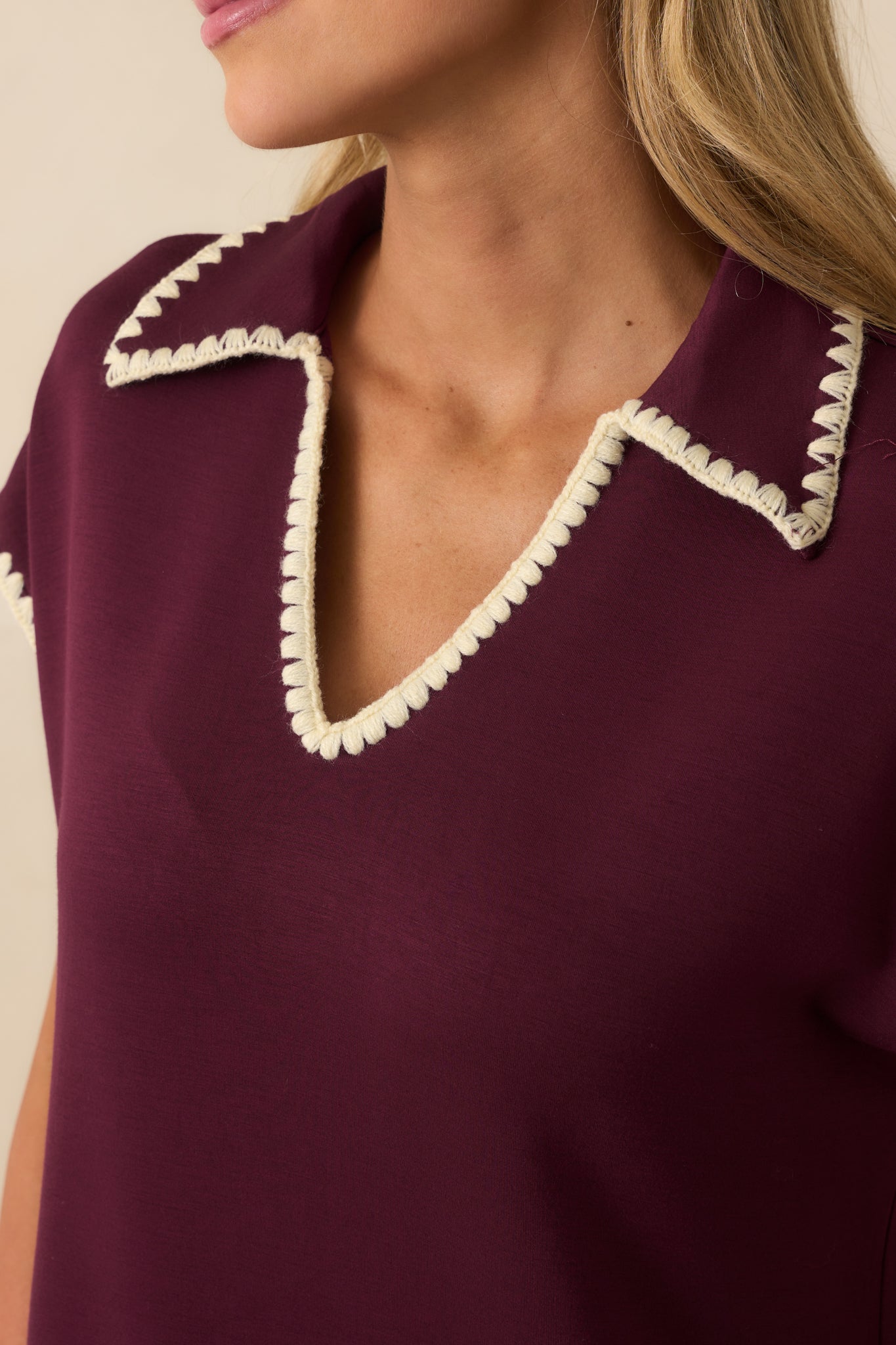 Detailed look at the ivory whipstitch trim and soft knit fabric of the plum maxi dress.