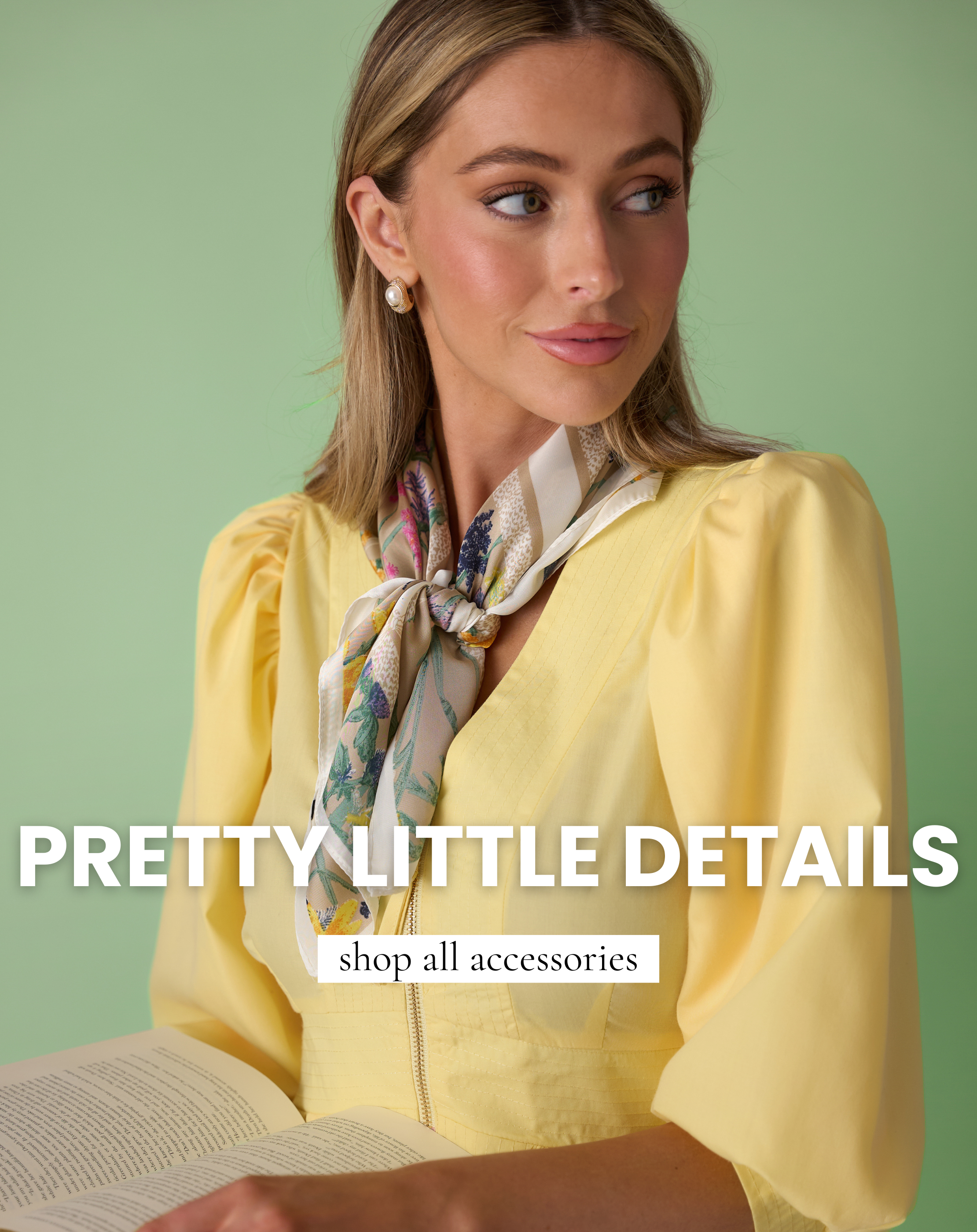 Woman wearing a yellow dress styled with a floral neck scarf and pearl earrings, holding an open book against a green background.