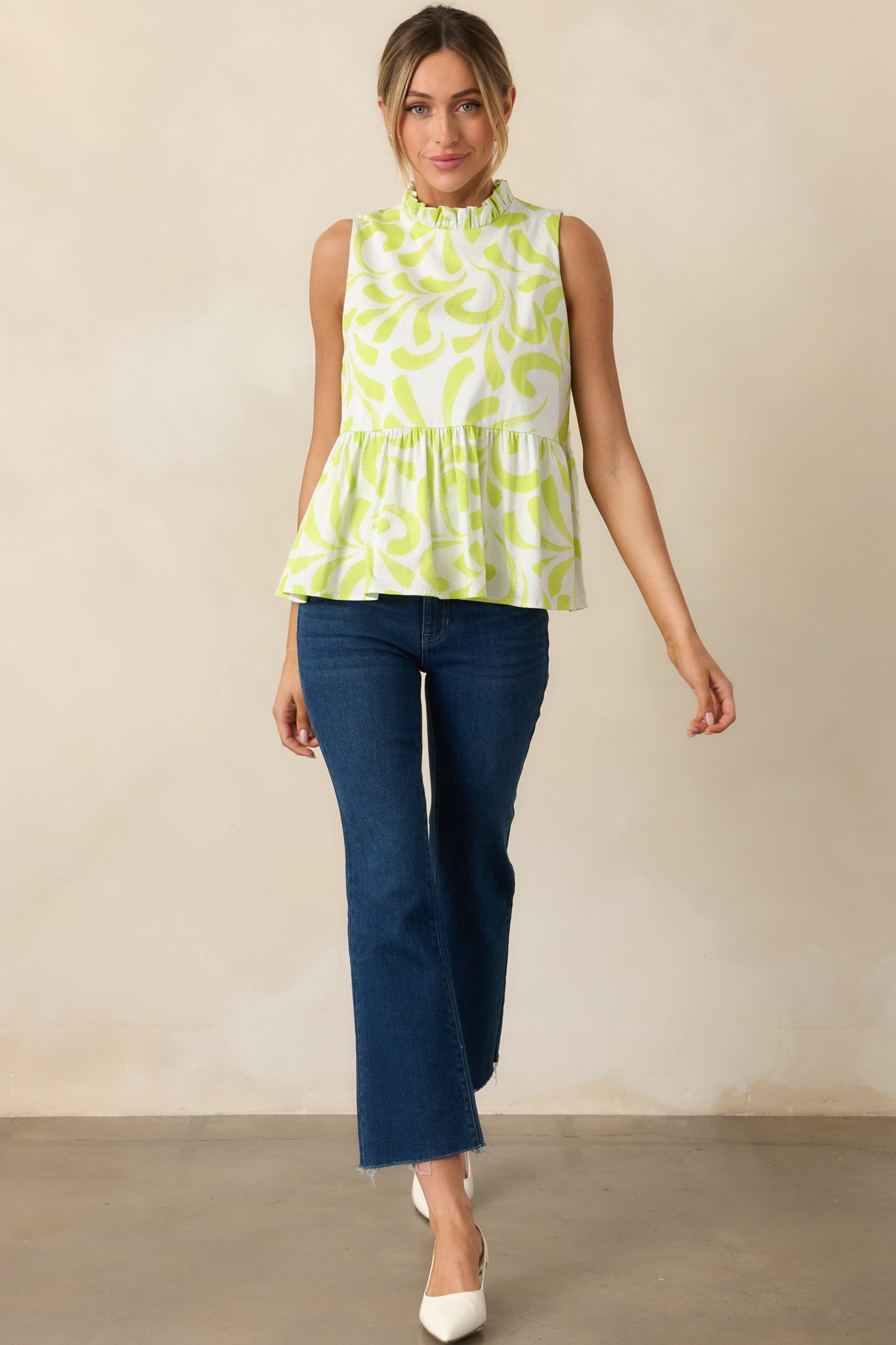 Front view of sleeveless top with lime green and white brush stroke print and ruffle mock neckline.