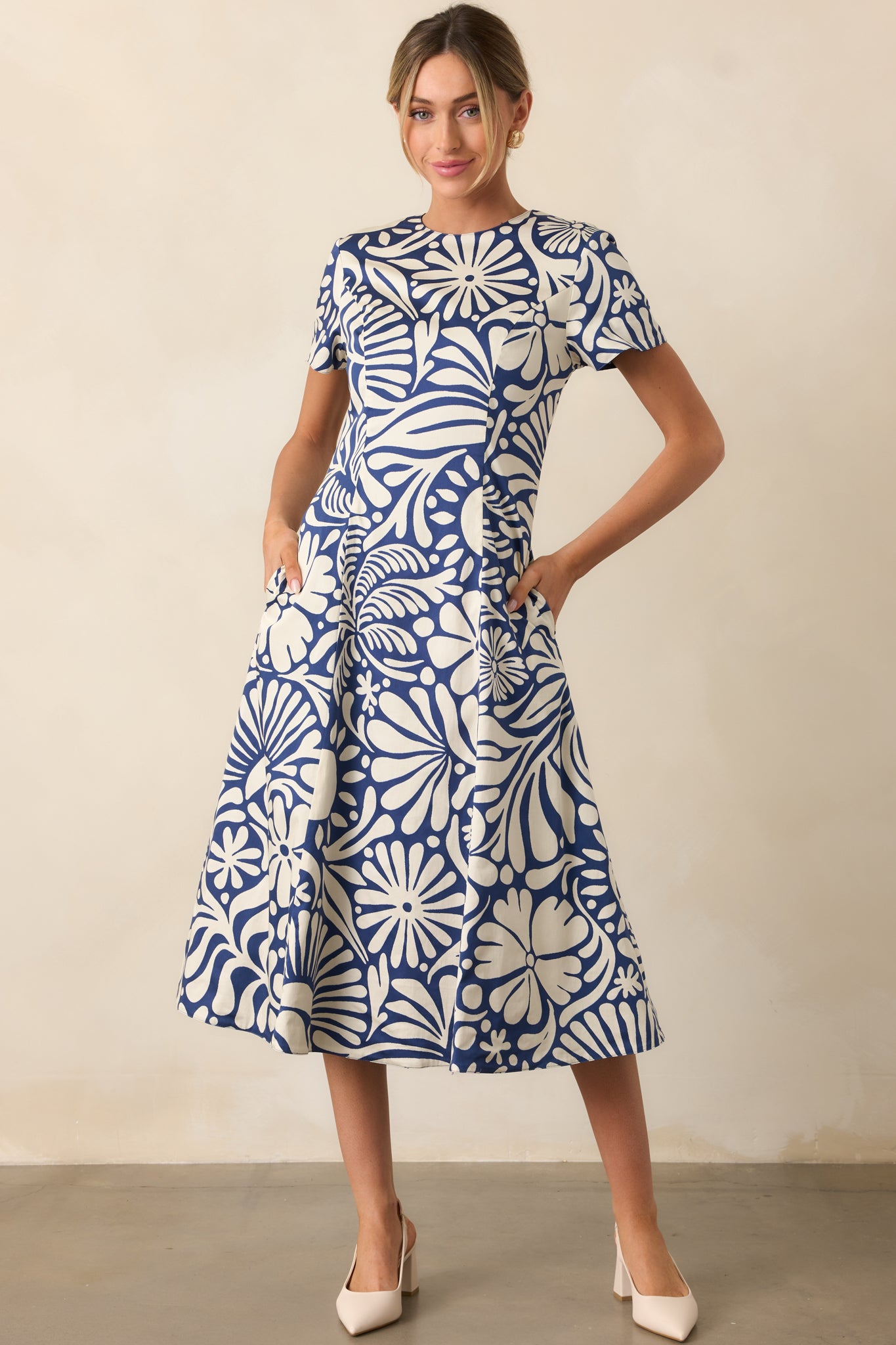 Midi dress with short sleeves and round neckline, displaying navy floral print and solid navy reverse side, front facing.