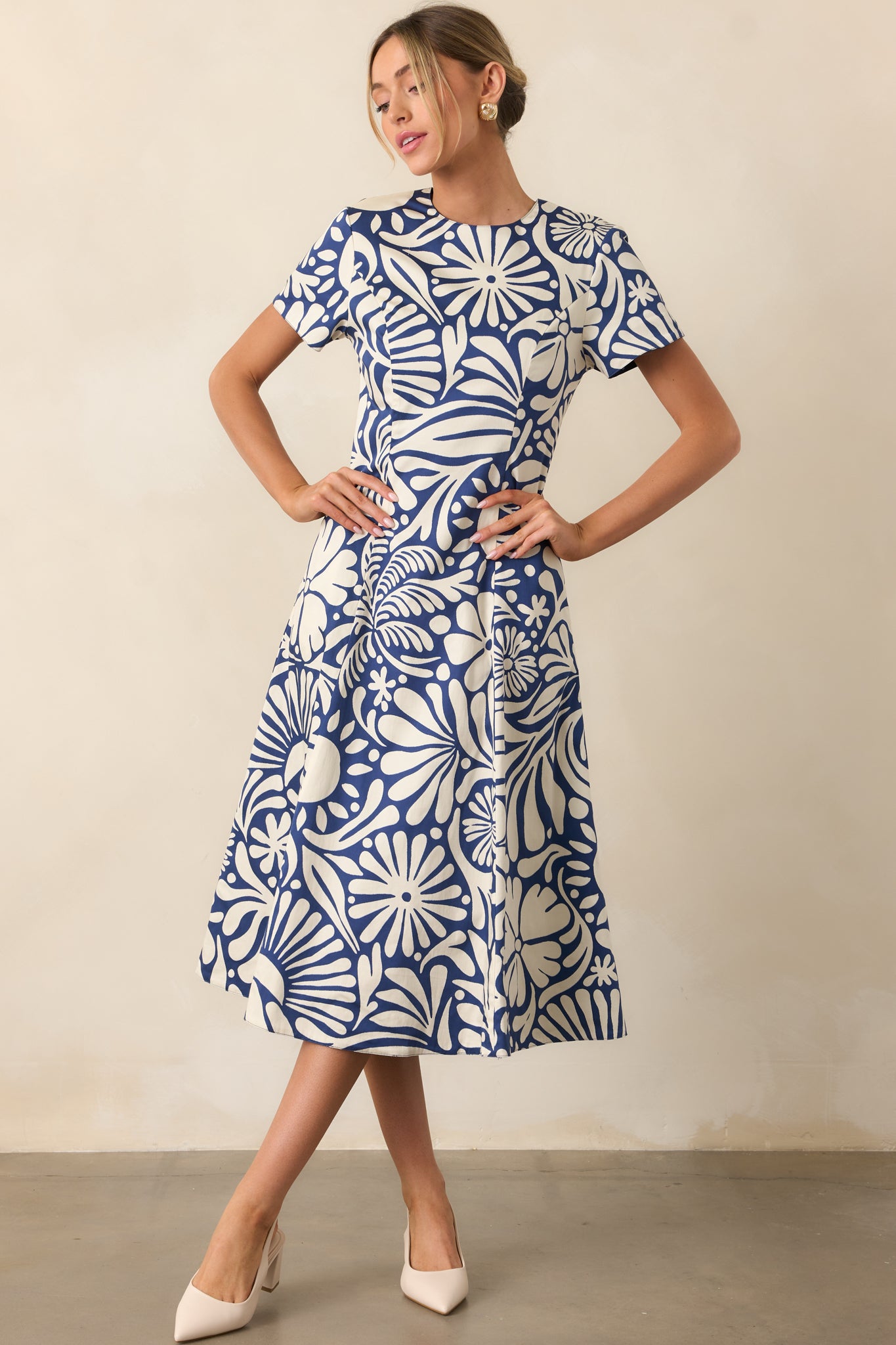Front view of midi dress featuring reversible fabric design, functional pockets, and fitted waist with flowy skirt.