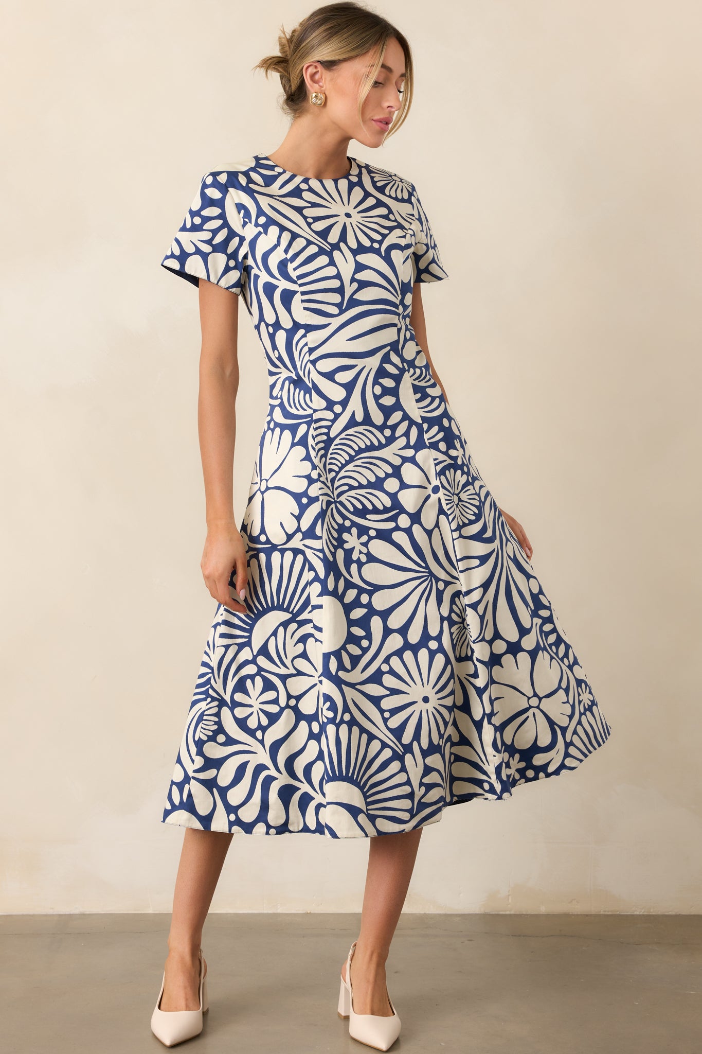 Reversible midi dress with short sleeves, round neckline, fitted waist, and flowy skirt, showing floral print on one side and solid navy on the other, front facing.