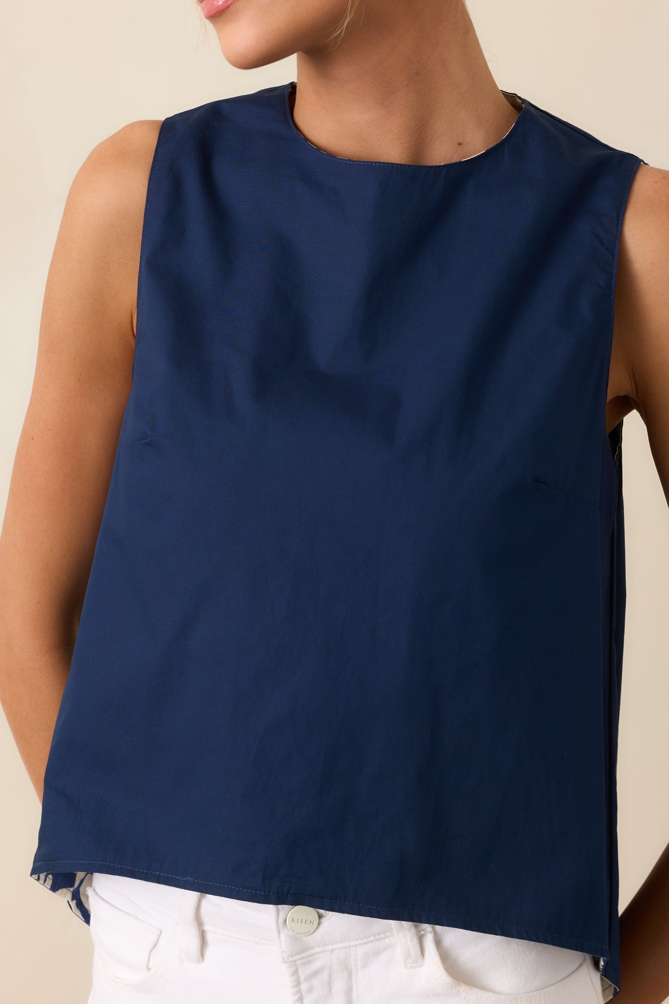 Close-up of top showing Prosperina Navy Mod Blossom floral print, fabric contrast, and hemline detail.