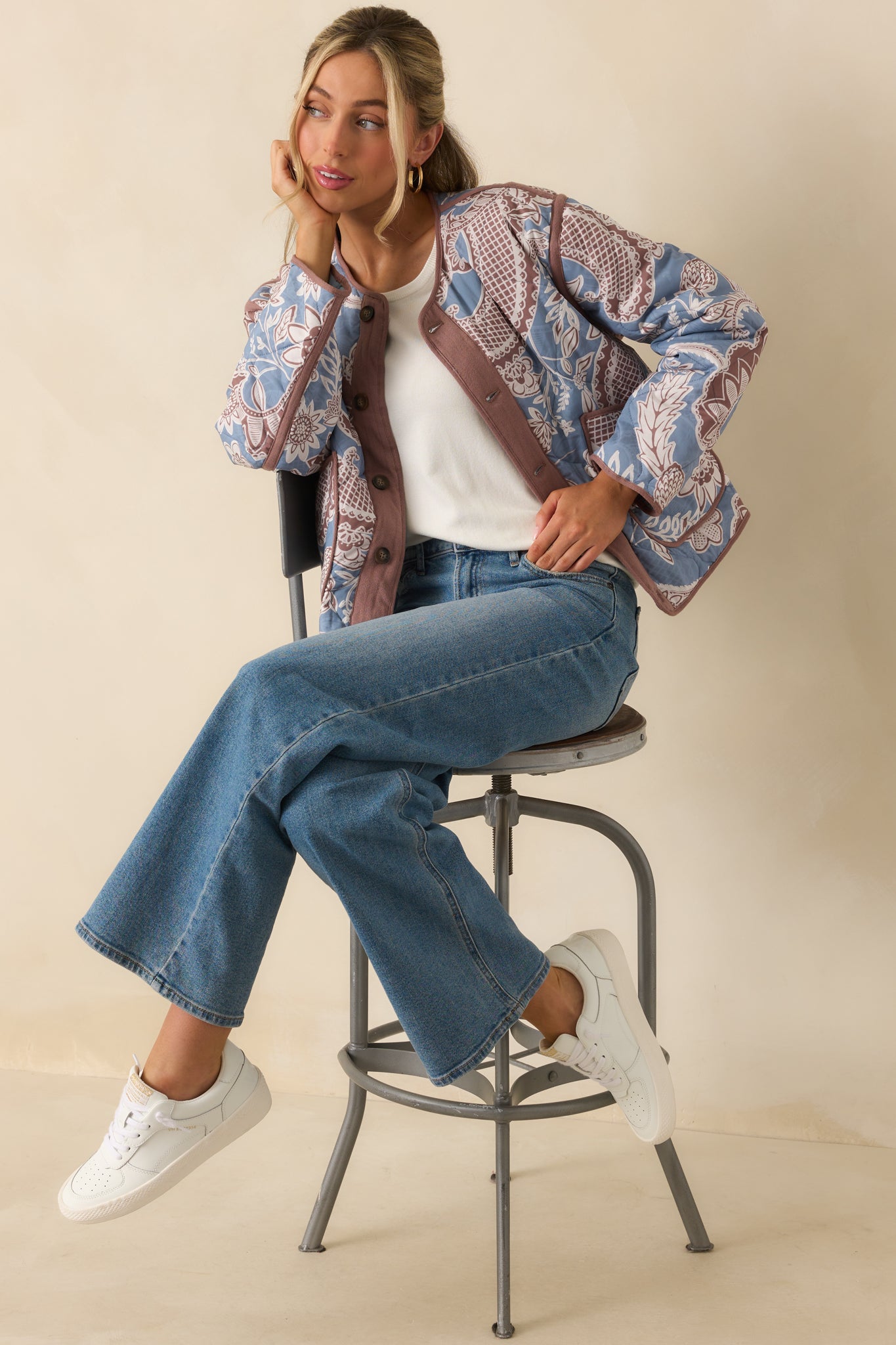 Quilted jacket styled fully showcasing the balanced paisley floral pattern and mauve trim accents.