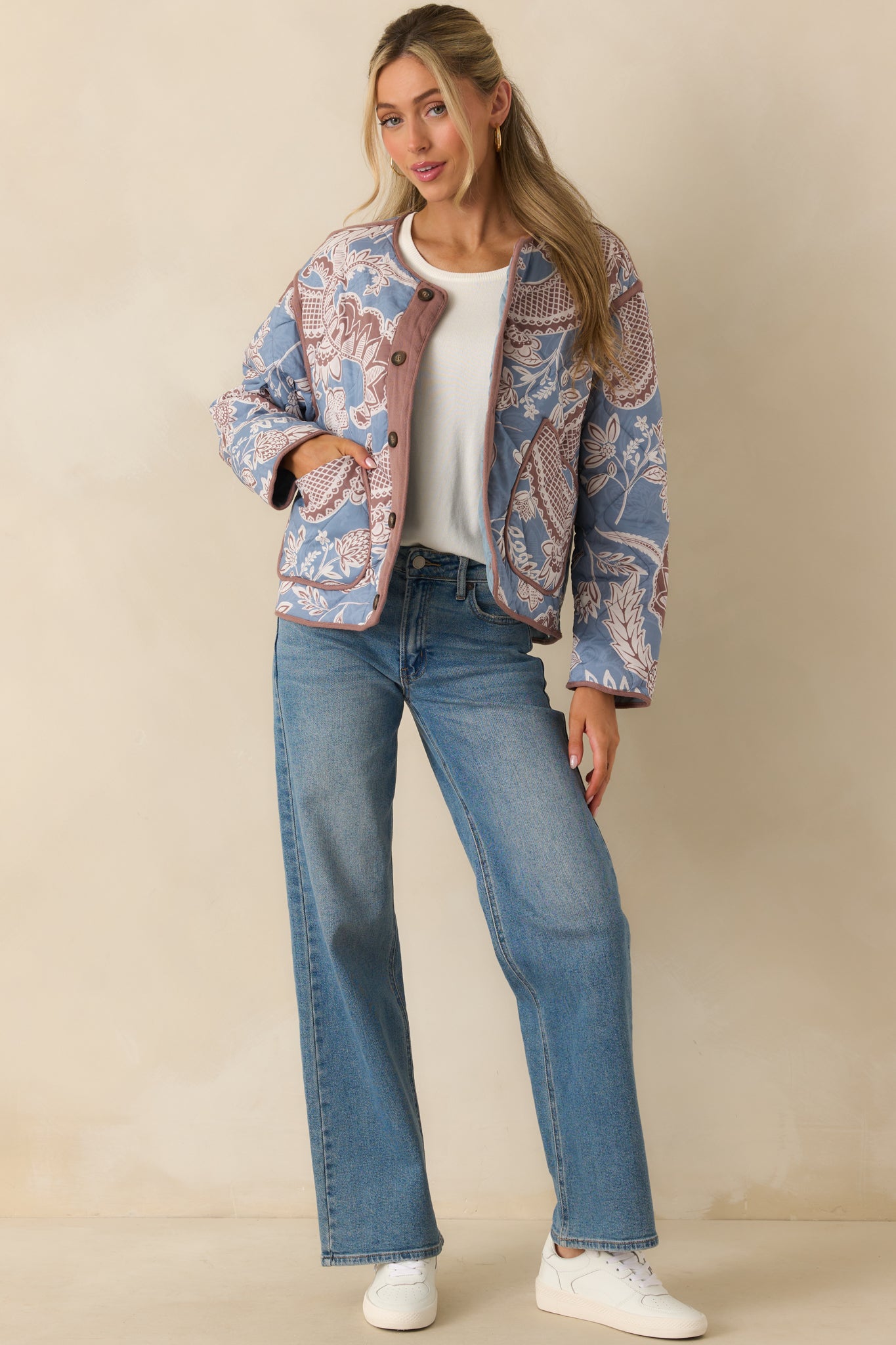 Quilted jacket displayed in a relaxed fit, emphasizing the floral paisley pattern and soft mauve accents.