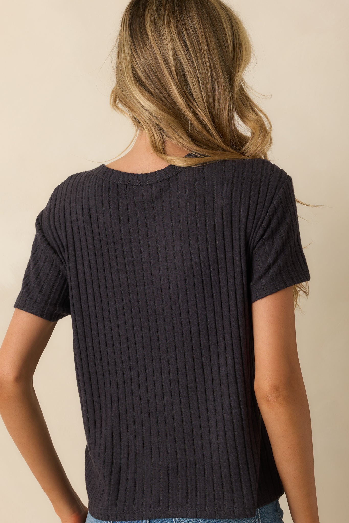 Rear view of the black ribbed tee with short sleeves and a relaxed boxy fit.