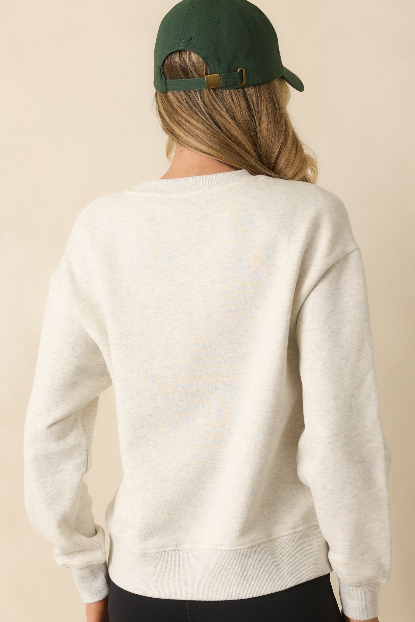 Rear view of the grey sweatshirt with a crew neckline and ribbed hemline.